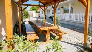 A wooden outdoor seating area with benches and potted plants.
