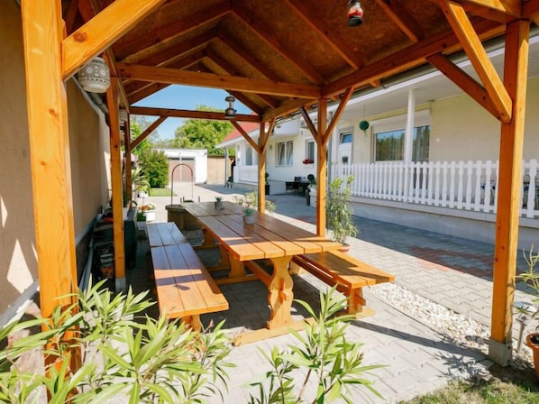 A wooden outdoor seating area with benches and potted plants. - Apartment Gabor by Interhome (Siofok)