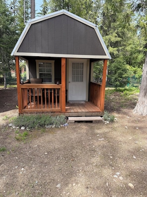 A small wooden cabin with a porch, a door, and a window. - Escape to Priest Lake! Cabin in the woods! Air Conditioning and WiFi!! (Nordman)