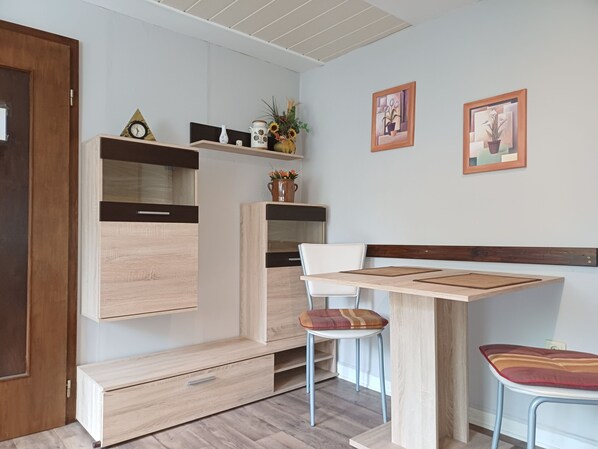 Une cuisine moderne avec des placards intégrés, une table à manger en bois, une chaise et un banc.