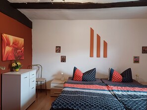 Een slaapkamer met een bed, een bureau, een stoel en een kledingkast.