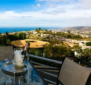 A table with a clear view of a coastal town, a glass pitcher, and a bottle. - Thanksgiving in Laguna! Best Value for Nov! View and Pet Friendly (Laguna Beach)