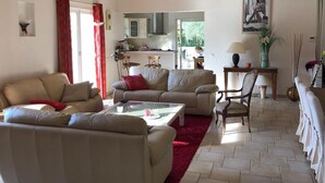 A spacious living room with a sofa, a coffee table, and a dining area with a table and chairs.