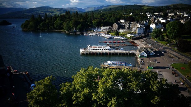 A coastal town with a marina, boats, and a large white building with a tower. - Claife View - Parking, Balcony, 1 min walk to central Bowness (Bowness-on-Windermere)