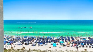 Una playa con muchos sombrillas y gente.