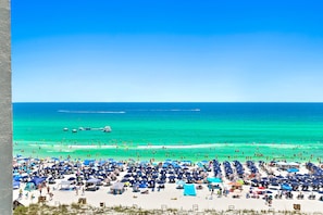 Une plage avec de nombreux parasols et beaucoup de baigneurs.