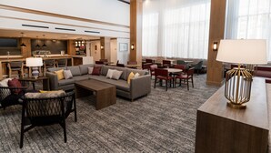 A spacious hotel lobby with a large sofa, dining area, and a bar. - Staybridge Suites Temecula Wine Country by IHG (Temecula)