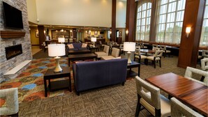 A spacious lobby with a fireplace, comfortable seating, a bar area, and large windows providing natural light. - Staybridge Suites Temecula Wine Country by IHG (Temecula)