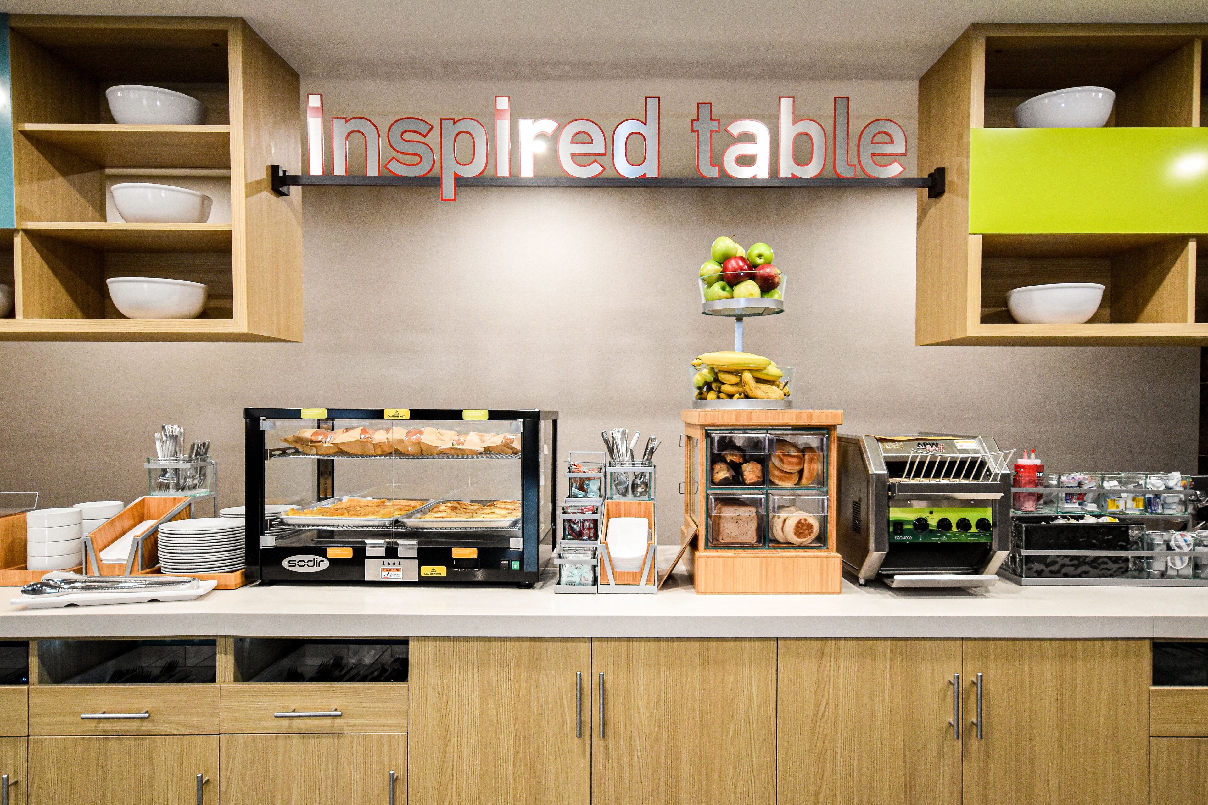 A buffet setup with various food items and a sign reading "inspired table".