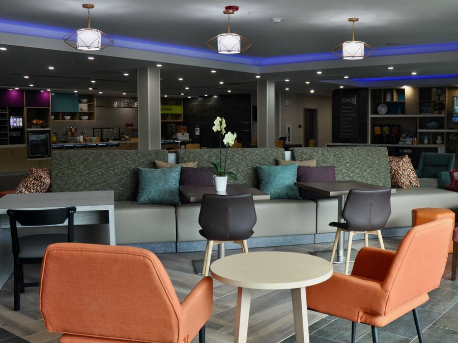 A modern lounge area with seating, a television, and a bar area.