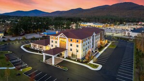 A hotel with a prominent 'HOME2' sign, a parking lot, and a mountainous backdrop. - Home2 Suites by Hilton North Conway (North Conway)