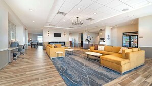 A spacious lobby with a large sofa, coffee table, and a patterned rug. - Best Western Plus Jefferson (Jefferson)