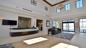 A spacious lobby with a reception desk, seating area, and large windows offering views.
