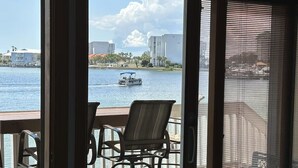 Un balcón con vistas al agua, un barco y edificios en la distancia.