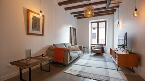 A living room with a sofa, a coffee table, a TV stand, and a large window. - LaSuitedu12 - Aprtement for 2 people view of the Old Prison (Annecy)
