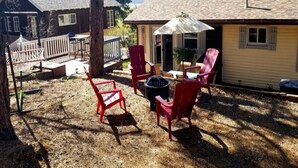 A backyard with red chairs, a table, and a fire pit. - Hillside Cottage In The Pines With Great Views (Williams)