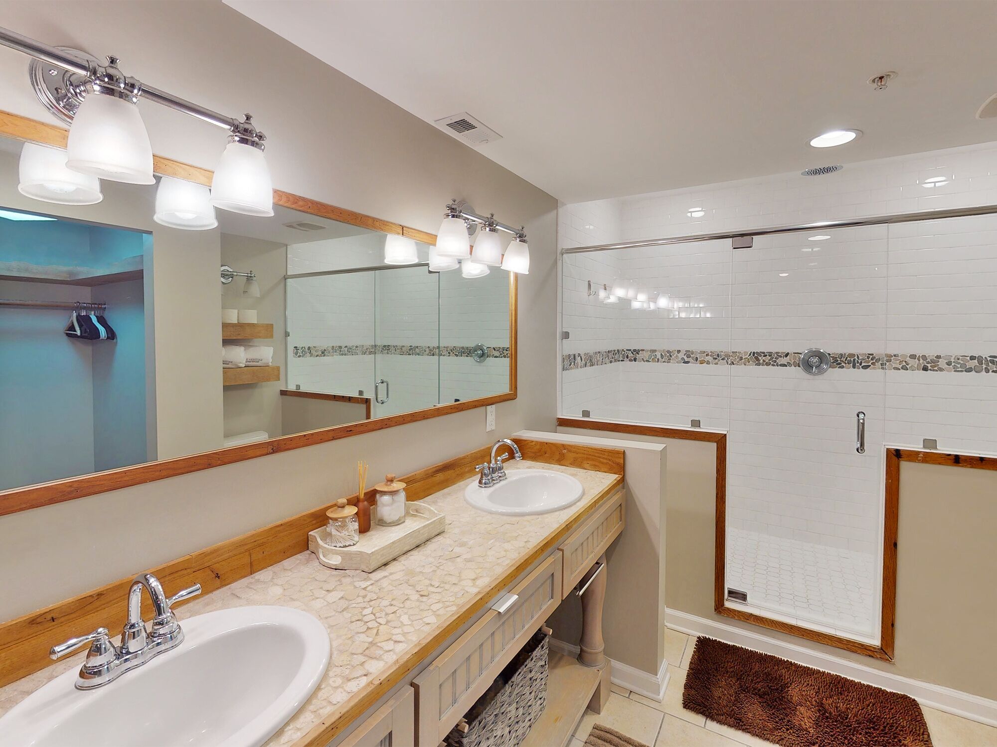 Un baño con dos lavamanos, un espejo grande y una zona de ducha.