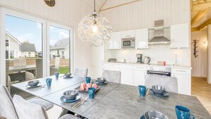 A modern kitchen with white cabinets, a stainless steel oven, and a hanging light fixture. - Pet friendly home in OstseeResort Olpenitz with sauna (OstseeResort Olpenitz)