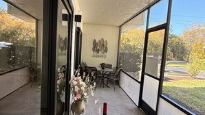 Un balcon avec une table dressée pour deux personnes, agrémenté d’une bouteille de vin, de verres et d’une bougie.