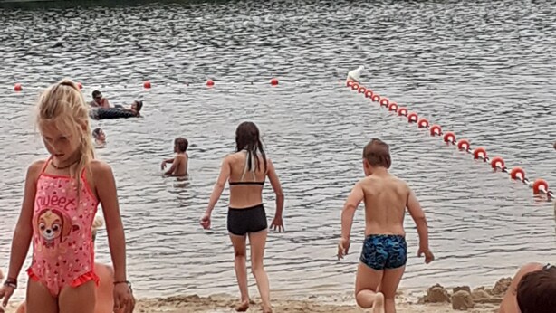 A beach with people walking along the shore and swimming in the water. - The house of happiness ⭐⭐⭐ (Fumay)