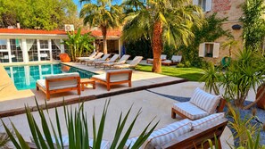 A pool area with lounge chairs and a stone building in the background. - Jardin d'Azur Alacati (Cesme)