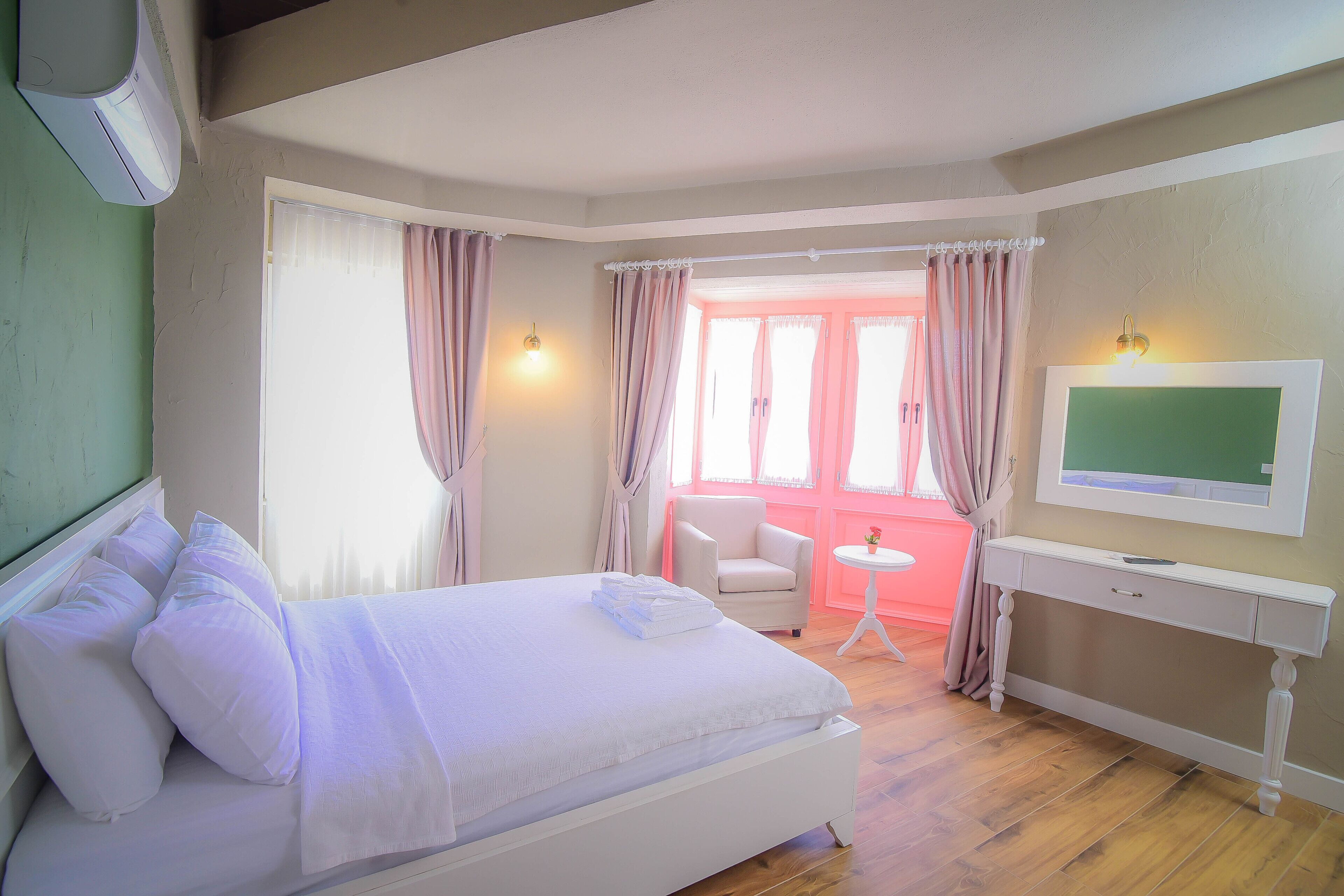 A bedroom with a bed, a desk, a chair, and a television.
