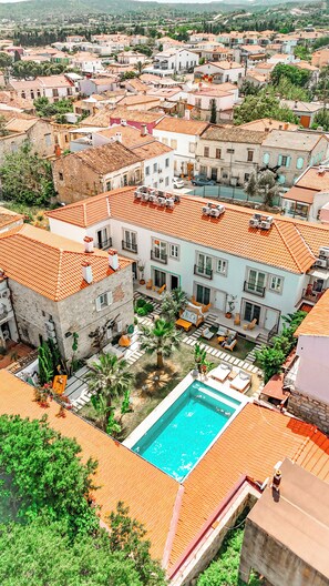 Un quartier résidentiel doté d’une piscine, entouré d’immeubles aux toits recouverts de tuiles orange.