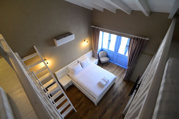 Chambre quadruple supérieure | Literie de qualité, minibar, coffre-fort, décor unique