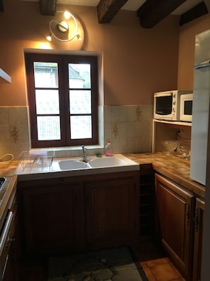 Compact kitchen with a central island featuring a sink and countertop, offering a view of the surrounding building.