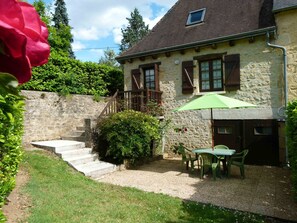 Experience the charm of this traditional stone house, surrounded by a beautifully maintained garden and outdoor dining area.
