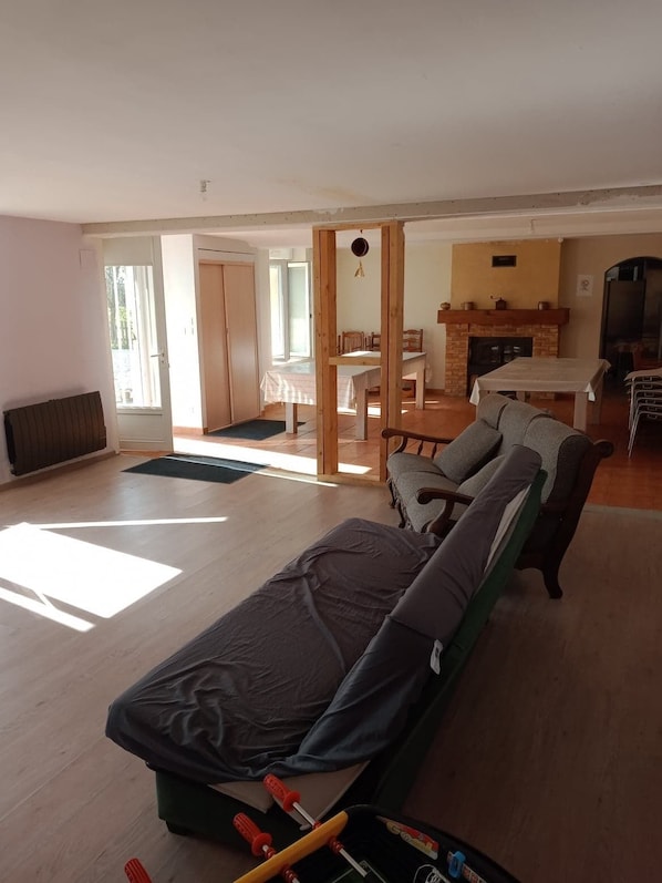 A spacious living area with a sofa, a dining table, and a fireplace.