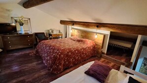 Ein Schlafzimmer mit einem Bett, einem hölzernen Schminktisch und einem Schreibtisch.