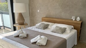 A neatly made bed with a brown blanket, white pillows, and folded towels.