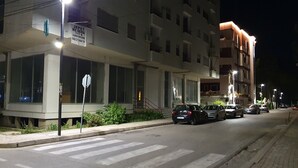 Un edificio a più piani con ampie vetrate e un cartello che indica un'attività commerciale al piano terra.