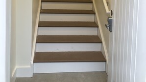 A staircase with a handrail, a door with a window, and a doorbell. - Bright new 2nd-floor space near Mayo Clinic & downtown (Rochester)