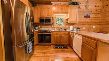 A modern kitchen with wooden cabinets, stainless steel appliances, and a window providing natural light.