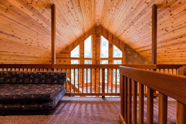 A cozy cabin interior with a wooden ceiling, a sofa, and a balcony with a railing. - Relaxing & Picturesque Gem ~ Game Room ~ View ~ EV (Helen)