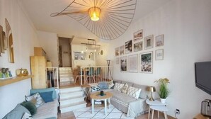 Un amplio salón con un conjunto de sofás, una mesa de centro y una escalera que lleva a un piso superior.