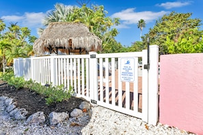 Enter a tranquil oasis with a thatched-roof structure and lush surroundings.