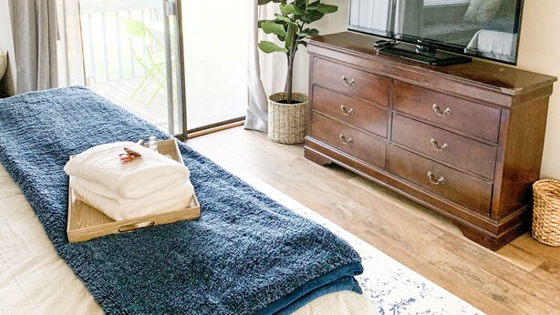 A bedroom with a bed, a dresser, a television, and a potted plant. - Cozy 2BR Lake Monroe Golf Condo IU Bloomington (Bloomington)