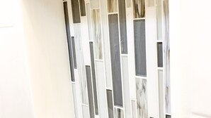 A bathroom with a white vanity and a tiled backsplash featuring rectangular tiles in various shades of gray and white. - Cozy 2BR Lake Monroe Golf Condo IU Bloomington (Bloomington)