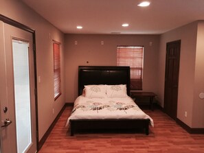 A bedroom with a bed, a wooden headboard, a nightstand, and a door. - Falcons Crest at Sequoyah Marina (Norris Lake) (Andersonville)