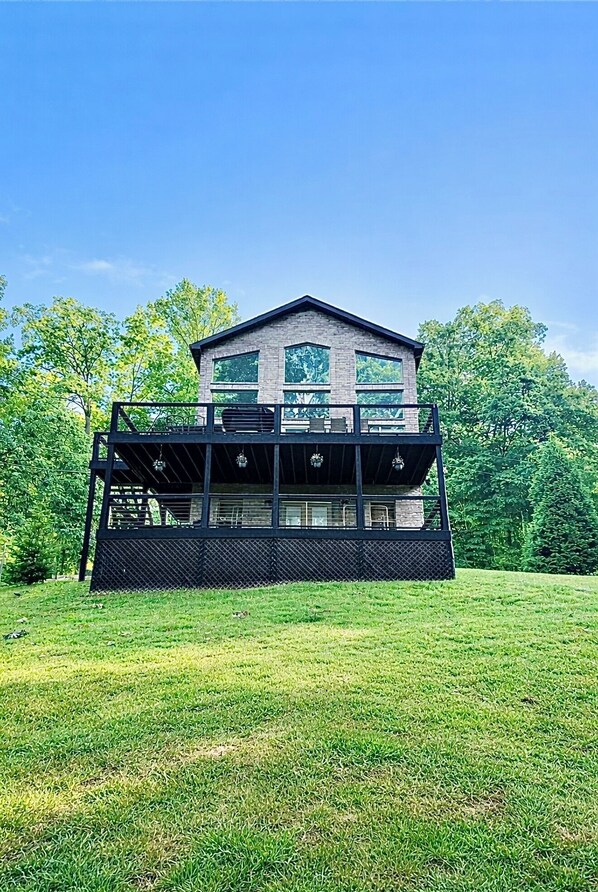 A two-story building with a balcony, surrounded by a grassy lawn and trees. - Falcons Crest at Sequoyah Marina (Norris Lake) (Andersonville)