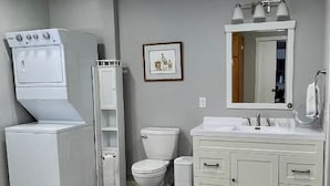 A bathroom with a washing machine, toilet, sink, and a mirror. - Little Country House a Quiet Countryside Getaway! (Newton)