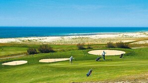 A golf course with sand bunkers, a clear view of the ocean, and a person playing golf. - VILLA BIDAOUS 4*-heated pool, table tennis, 3 bicycles, real table football-Messanges (Messanges)