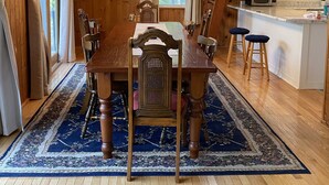 A wooden interior with a dining table, chairs, a kitchen area, and a staircase. - White Mountain Retreat, Waterville Estates Amenities  (Campton)