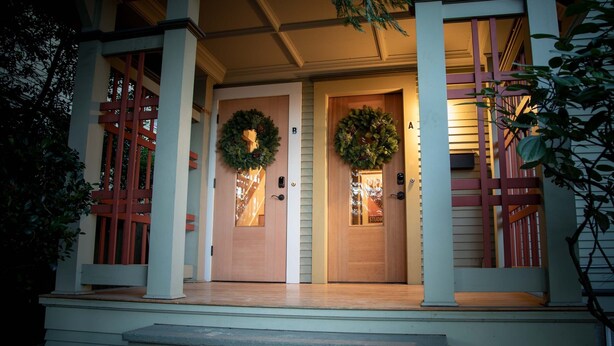 A front entrance with two doors, each adorned with a wreath.
