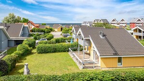 Ett bostadsområde vid kusten med hus som har sadeltak och en gräsyta framför.