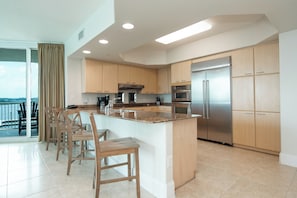 Una cocina moderna con una isla central, electrodomésticos de acero inoxidable y armarios de madera.