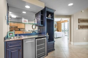 A modern kitchen with a built-in refrigerator, a glass shelf, and a dark wooden cabinet.